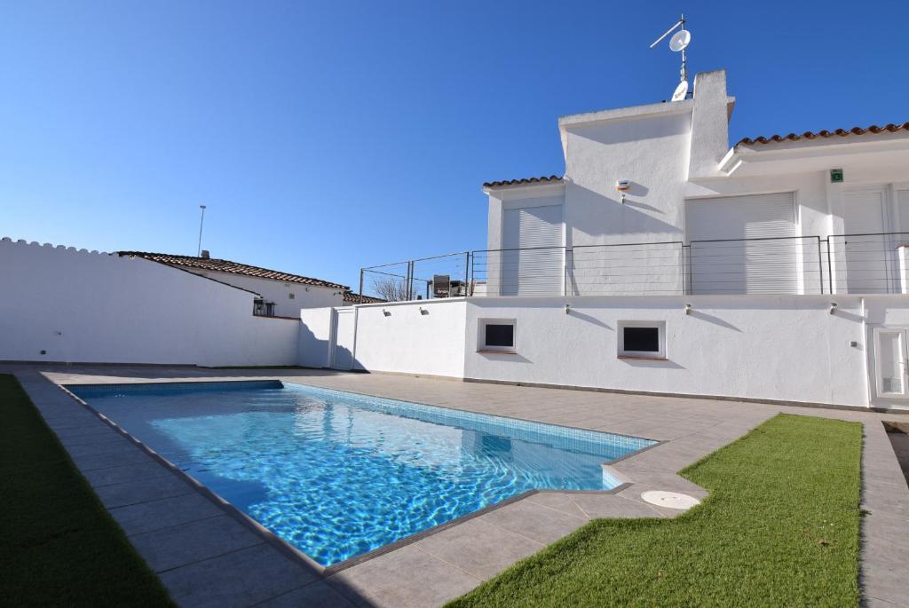 a villa with a swimming pool in front of a house at casa con piscina privada y cerca playa ref 382 in Empuriabrava
