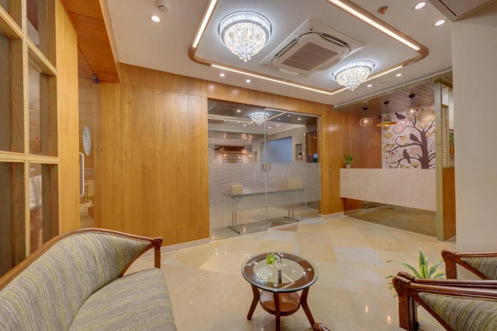 a lobby with chairs and a table in a building at The Beacon Hotel Vadodara in Vadodara