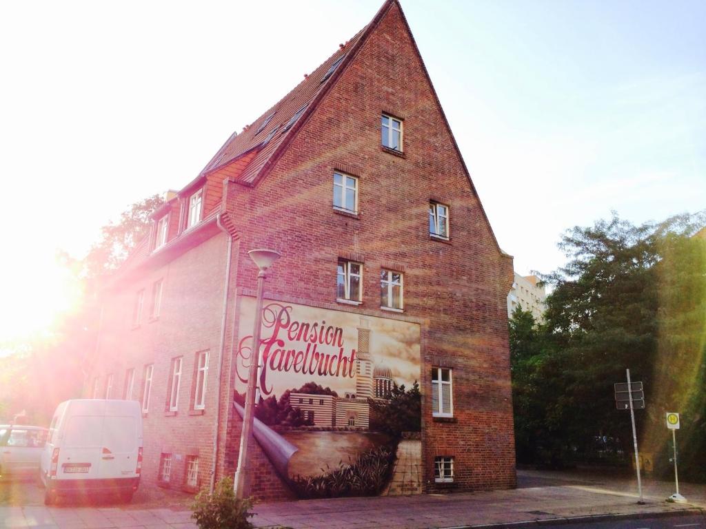a brick building with a sign on the side of it at Pension an der Havelbucht in Potsdam