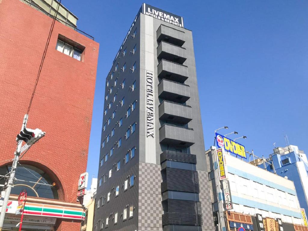 een hoog gebouw met een hotelbord erop bij HOTEL LiVEMAX Chiba Chuo-Ekimae in Chiba