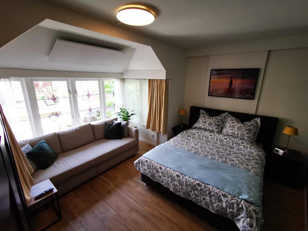 ein Wohnzimmer mit einem Bett und einem Sofa in der Unterkunft Unique Courtyard House with Sauna in Alkmaar city center in Alkmaar
