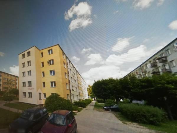 eine Straße mit zwei Gebäuden und einem Auto neben der Unterkunft in der Unterkunft Apartament Parkowy 2 pokojowy in Mrągowo