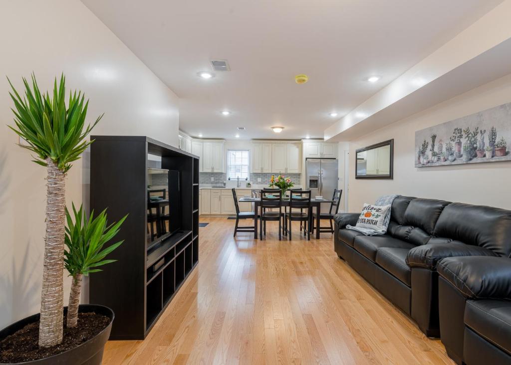 a living room with a black leather couch and a table at 41-Convenient Townhouse in Quincy
