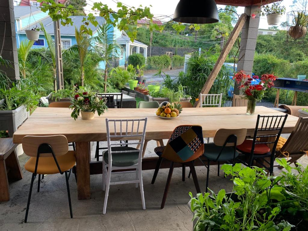 - une table et des chaises en bois dans le jardin dans l'établissement Madeleine Rose, à Cilaos