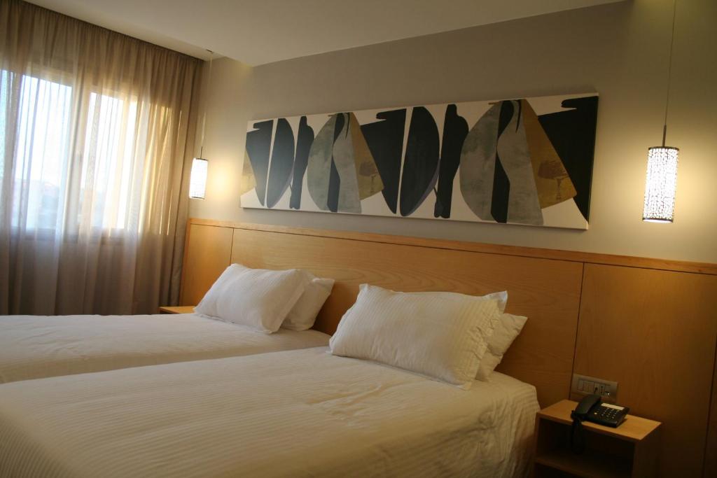 a hotel room with two beds and a painting on the wall at Valley Boutique Hotel in Safi