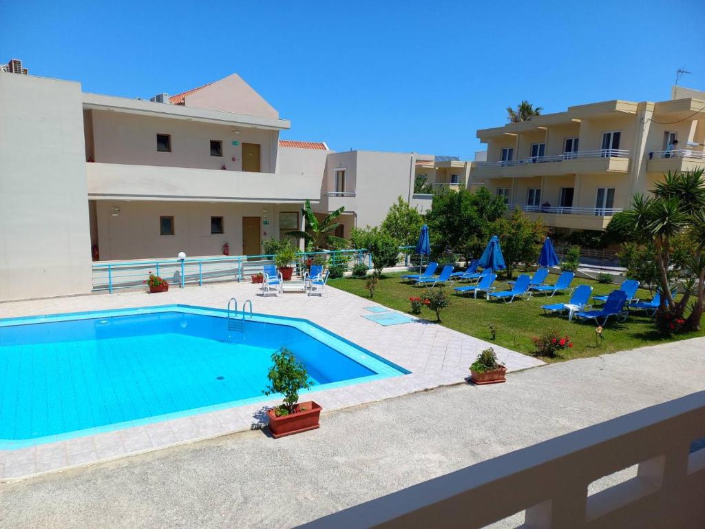 a large swimming pool in front of a building at Litinas Apartments in Agia Marina Nea Kydonias