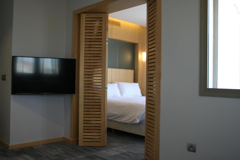 a bedroom with a bed and a flat screen tv at Valley Boutique Hotel in Safi