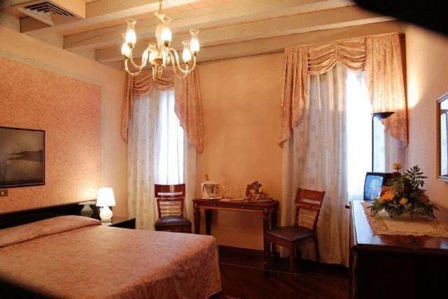 a bedroom with a bed and a table and a desk at Hotel Aldo Moro in Montagnana