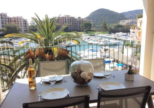 - une table avec des verres à vin et une vue sur le port dans l'établissement F3 ILE MARINA MANDELIEU LA NAPOULE, à Mandelieu-la-Napoule