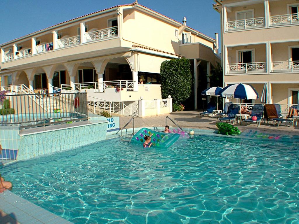 two people playing in a swimming pool in a hotel at Roseland Hotel in Kalamaki