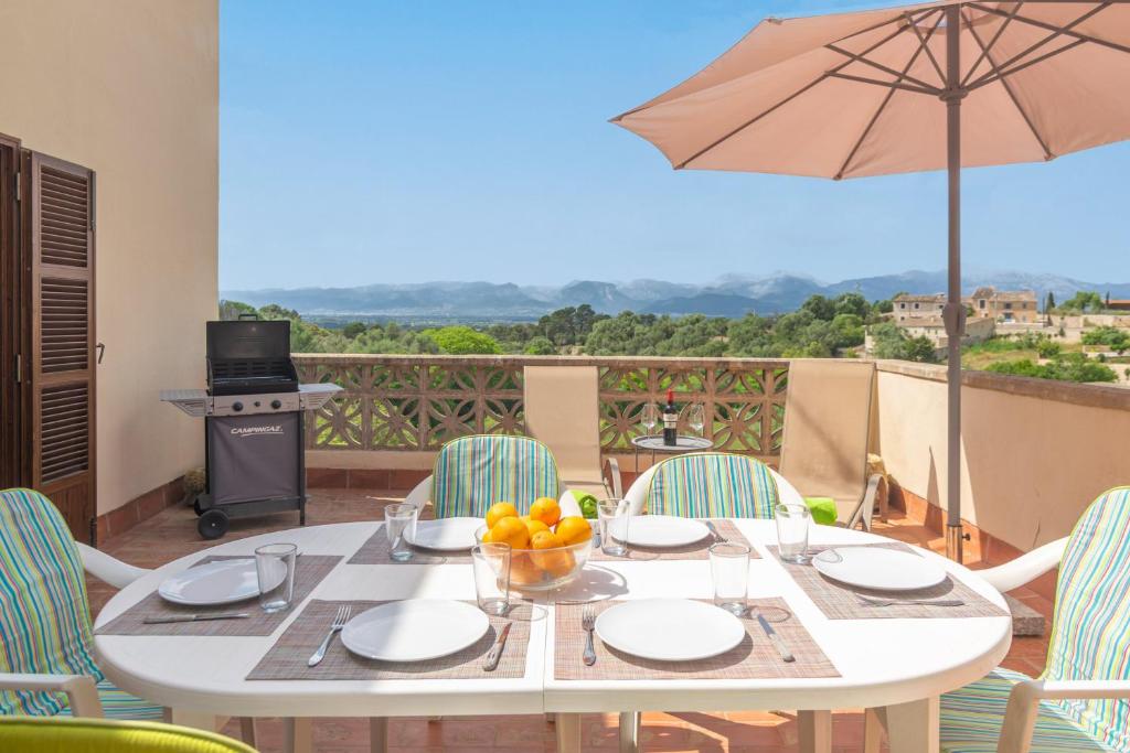 een witte tafel met stoelen en een parasol op een balkon bij Can Rei -Costitx- in Costitx