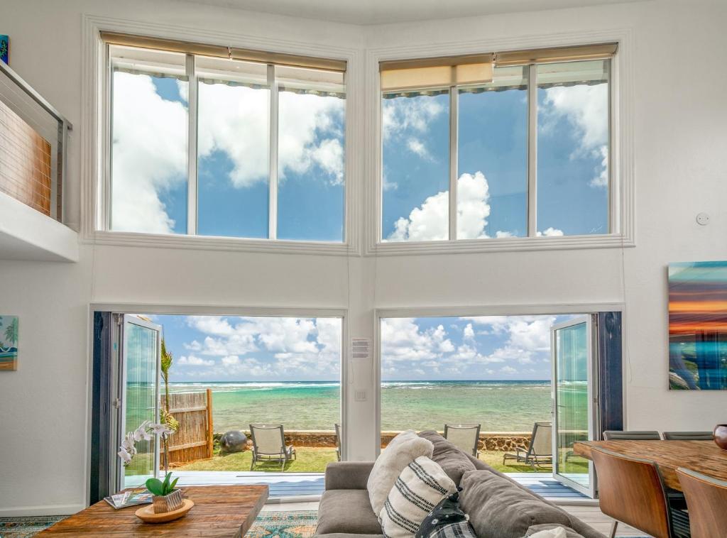 - un salon avec une grande fenêtre donnant sur l'océan dans l'établissement Bond House home, à Anahola