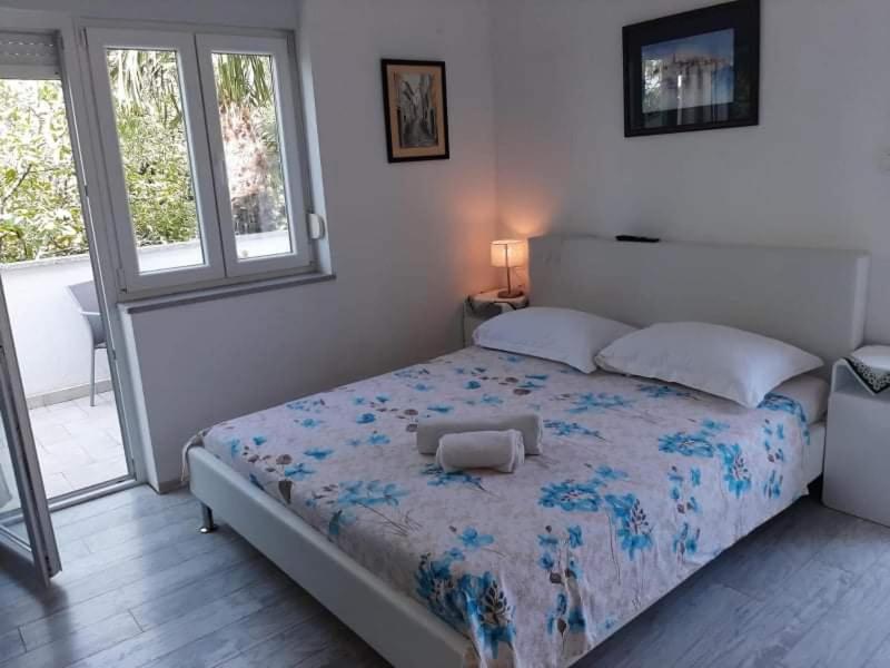 a bedroom with a large bed with a blue comforter at Fiore apartment & room in Krk