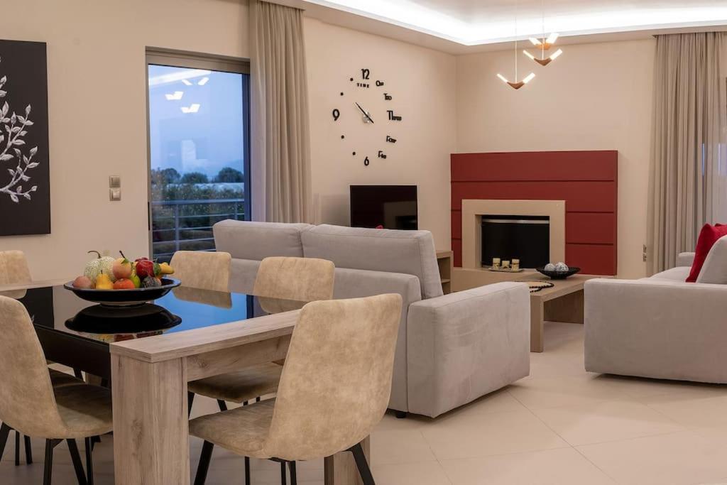 uma sala de estar com uma mesa e cadeiras e um sofá em ''Aeolos'' Luxury Villa em Preveza