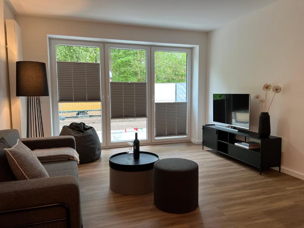 a living room with a couch and a tv at Apartmenthaus Stade Schwingewiesen Apartment 5 in Stade