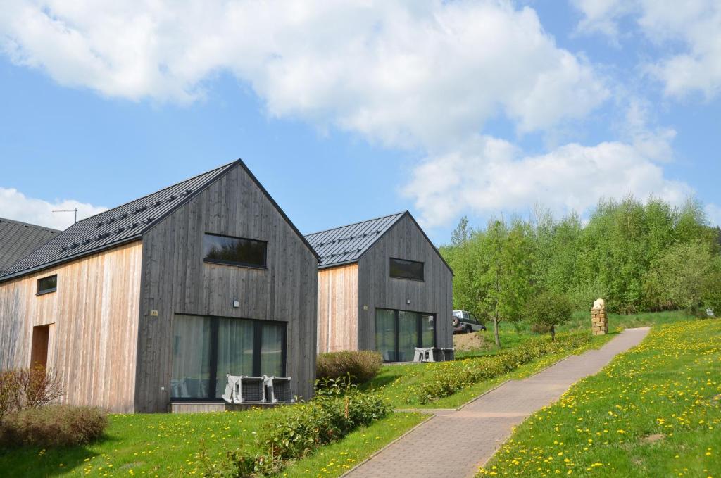 two black barns with a path in front of it at Slonovy CHaty in Dolní Morava