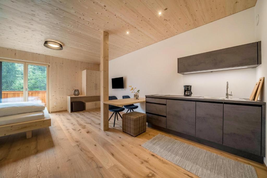 1 dormitorio con cama y escritorio en Naturapartments Alpreid Feine, en San Pancrazio