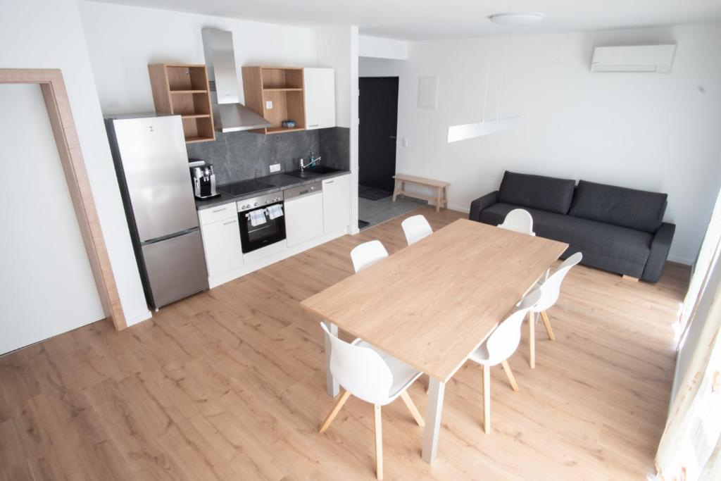 eine Küche und ein Wohnzimmer mit einem Holztisch und Stühlen in der Unterkunft Family XL - Bungalows in Lutzmannsburg