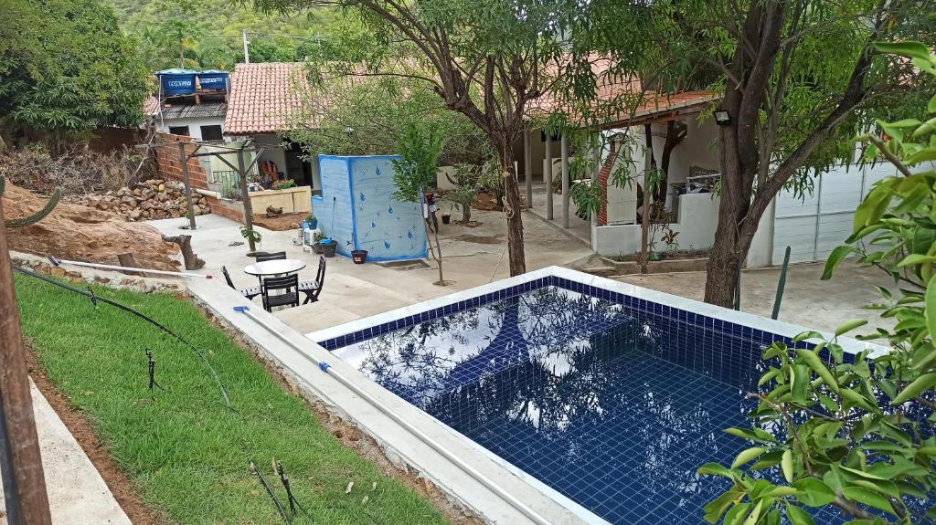 a swimming pool in a yard with a house at Quitinetes Beira Rio in Canindé de São Francisco