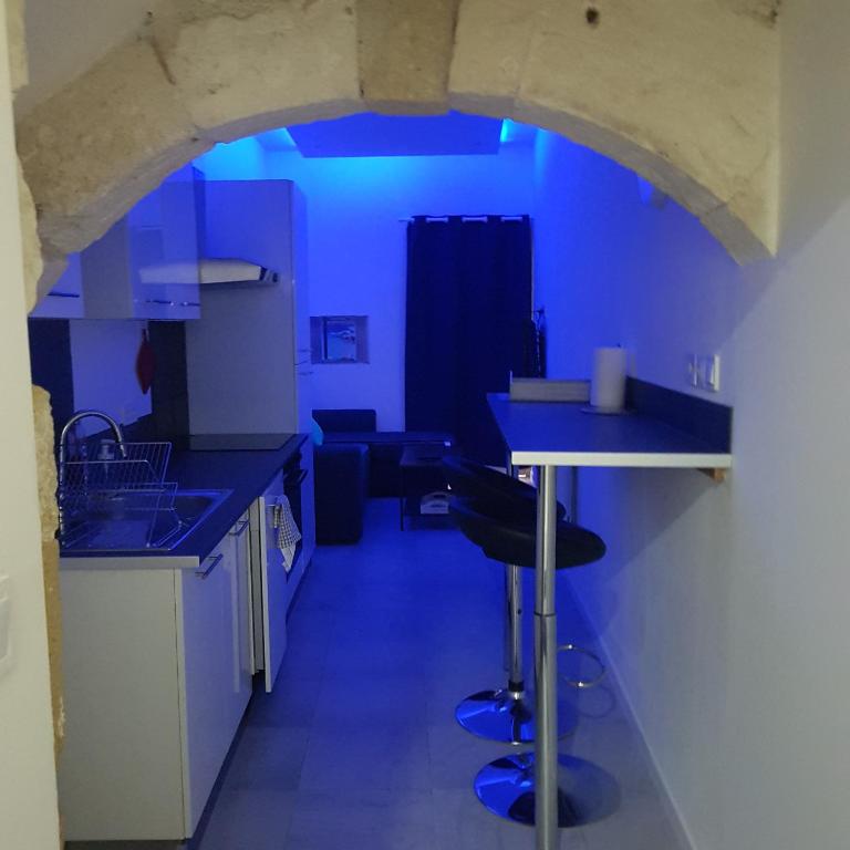 a kitchen with blue lighting in a room at Appart 40m2 indépendant, confortable avec terasse in Lunel