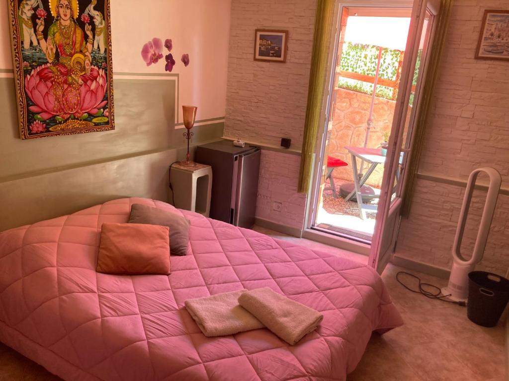 - une chambre avec un lit rose et des oreillers dans l'établissement chambre double avec salle de bain privée, à Monacia-dʼAullène