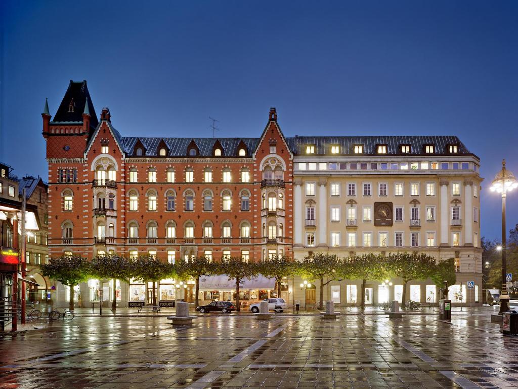 ein großes Gebäude in der Nacht mit eingeschaltetem Licht in der Unterkunft Nobis Hotel Stockholm, a Member of Design Hotels™ in Stockholm