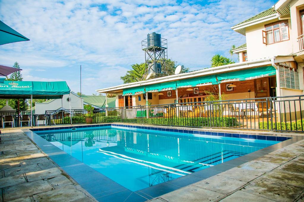 a swimming pool in front of a building at Fort Motel in Fort Portal