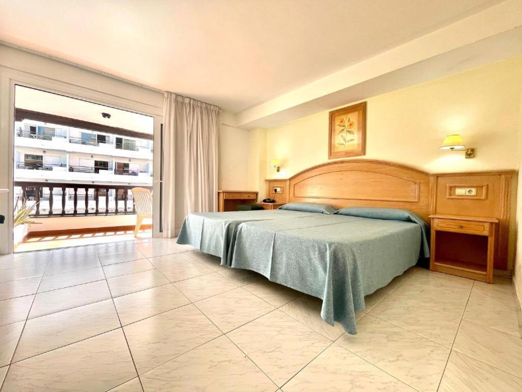 1 dormitorio con cama grande y ventana grande en Apartamentos Park Plaza, en Puerto de la Cruz