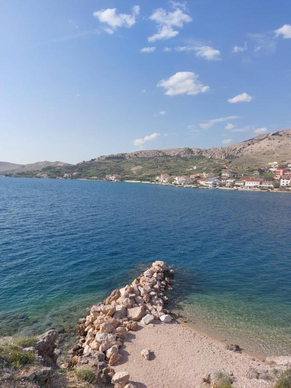 a large body of water with a rocky shore at Apartments Markulincic in Novalja