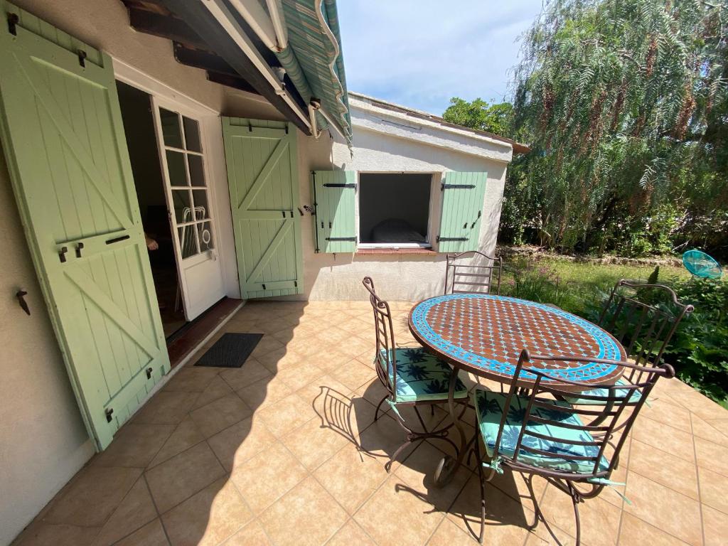 une terrasse avec une table et des chaises ainsi qu'une maison dans l'établissement La Muscadiere, à Fréjus