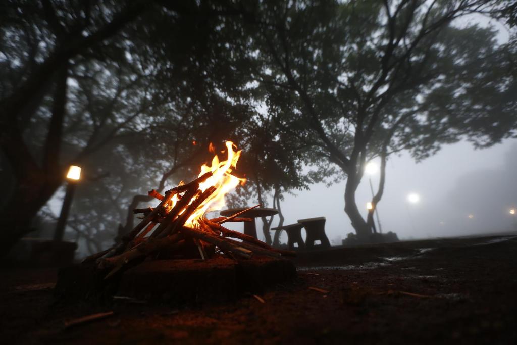 un incendio en un parque con árboles en el fondo en Ashoka Villa 3 BHK Mahabaleshwar, en Mahabaleshwar