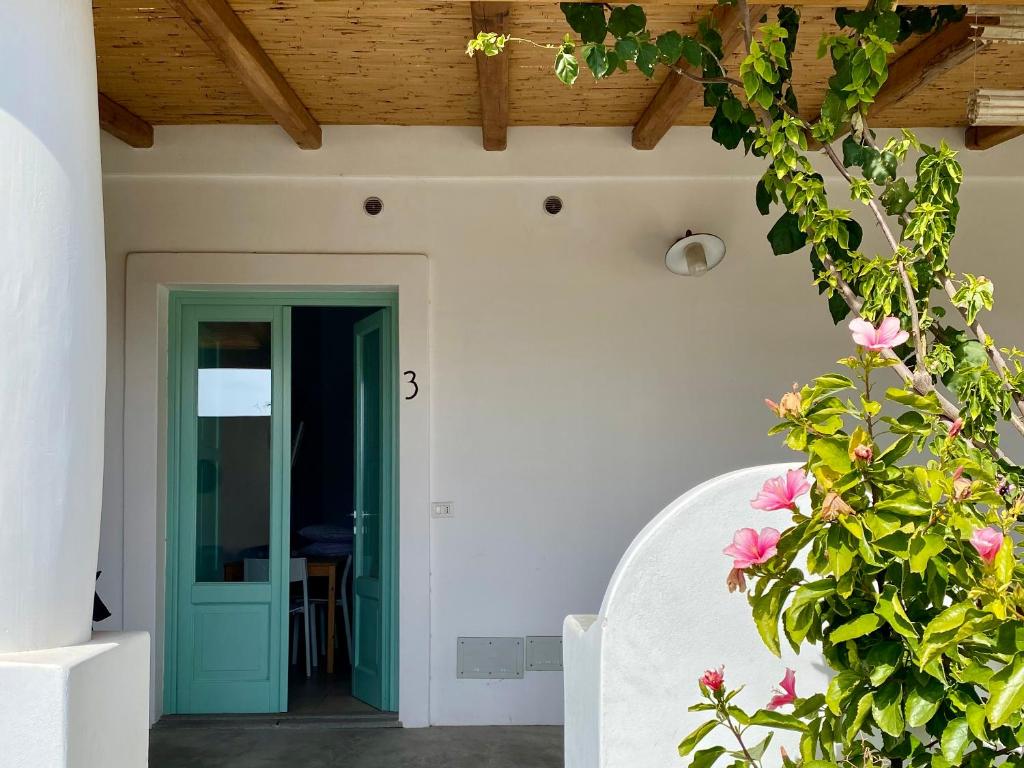 a house with a green door and flowers at Appartamenti Alba&Tramonto in Stromboli