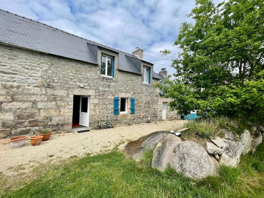 an old stone house with a yard in front of it at Maison de charme entre terre et mer, proche plages in Névez