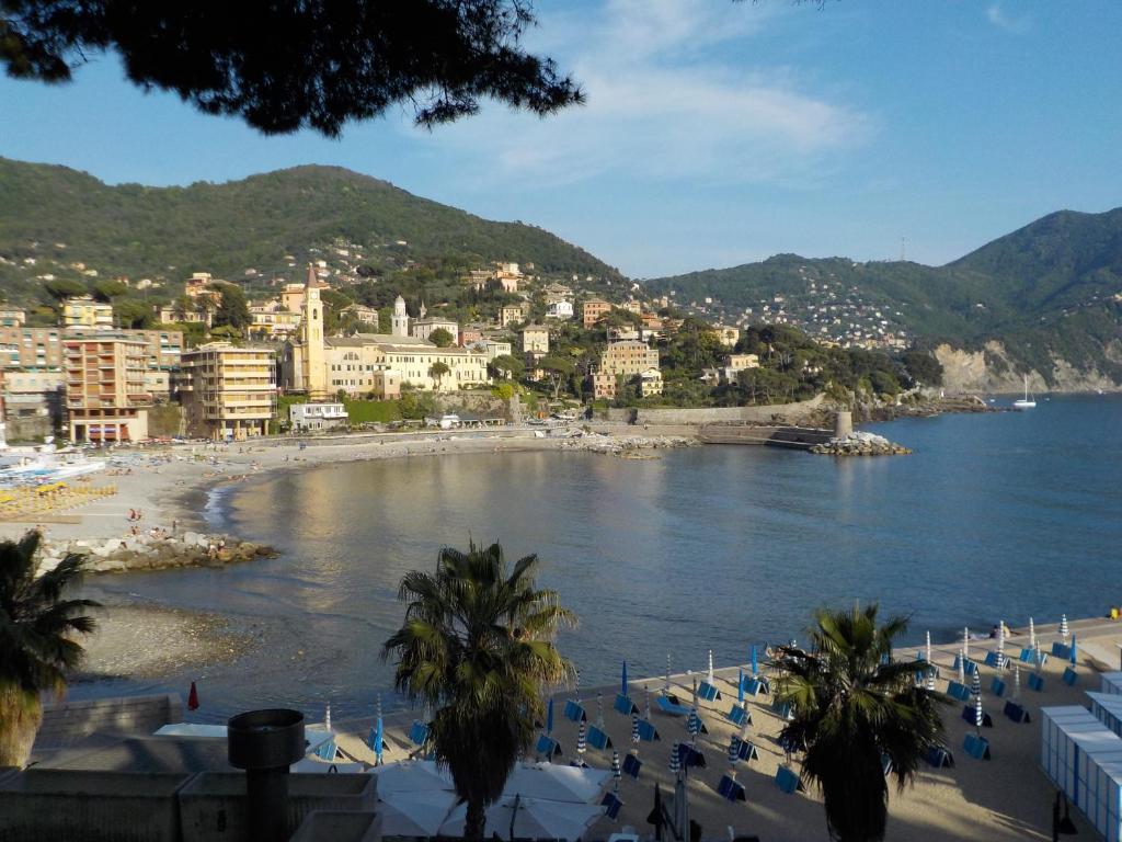 a view of a beach with buildings and palm trees at La casa di Yuri - Free Private Parking & Air Conditioning in Recco