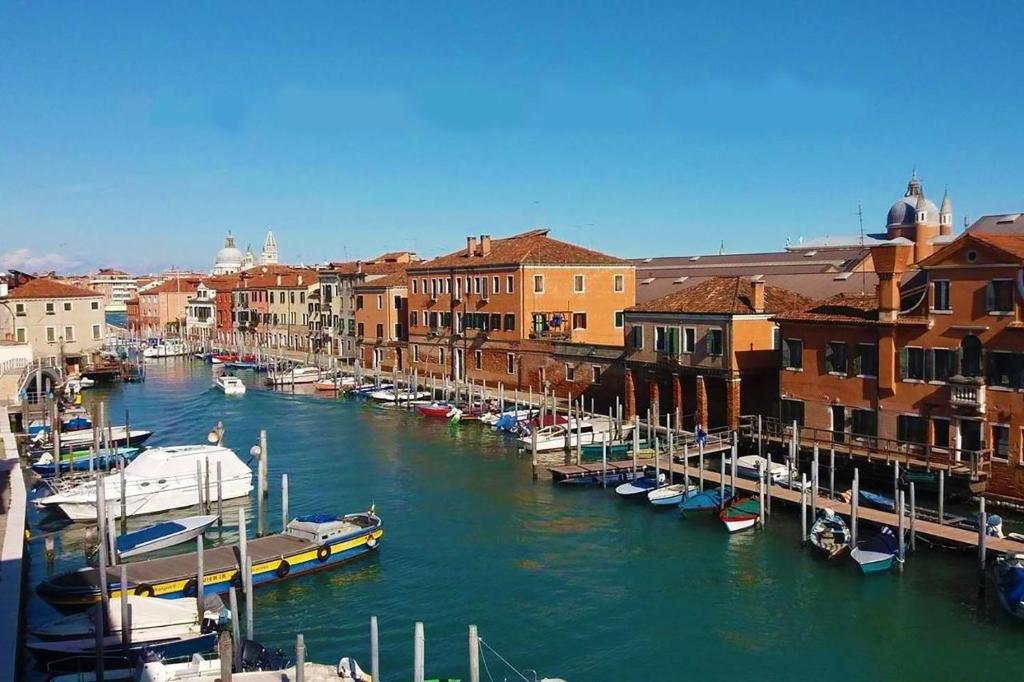 un gruppo di imbarcazioni ormeggiate in un canale con edifici di Residence Laguna Giudecca a Venezia