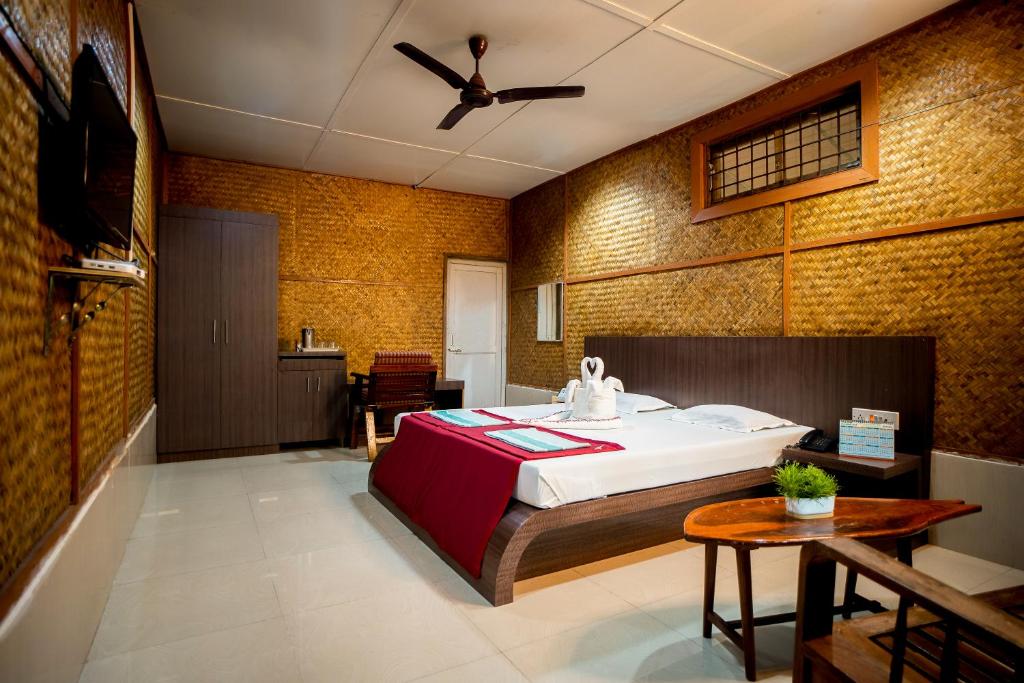 Palm Grove Eco Resort في ميناء بلير: غرفة نوم فيها سرير وطاولة فيها