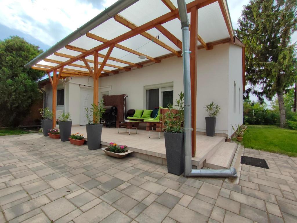 pergola na patio ze stołem i krzesłami w obiekcie Elizabeth Vendégház Balatonfűzfőn a Strandnál w mieście Balatonfůzfő