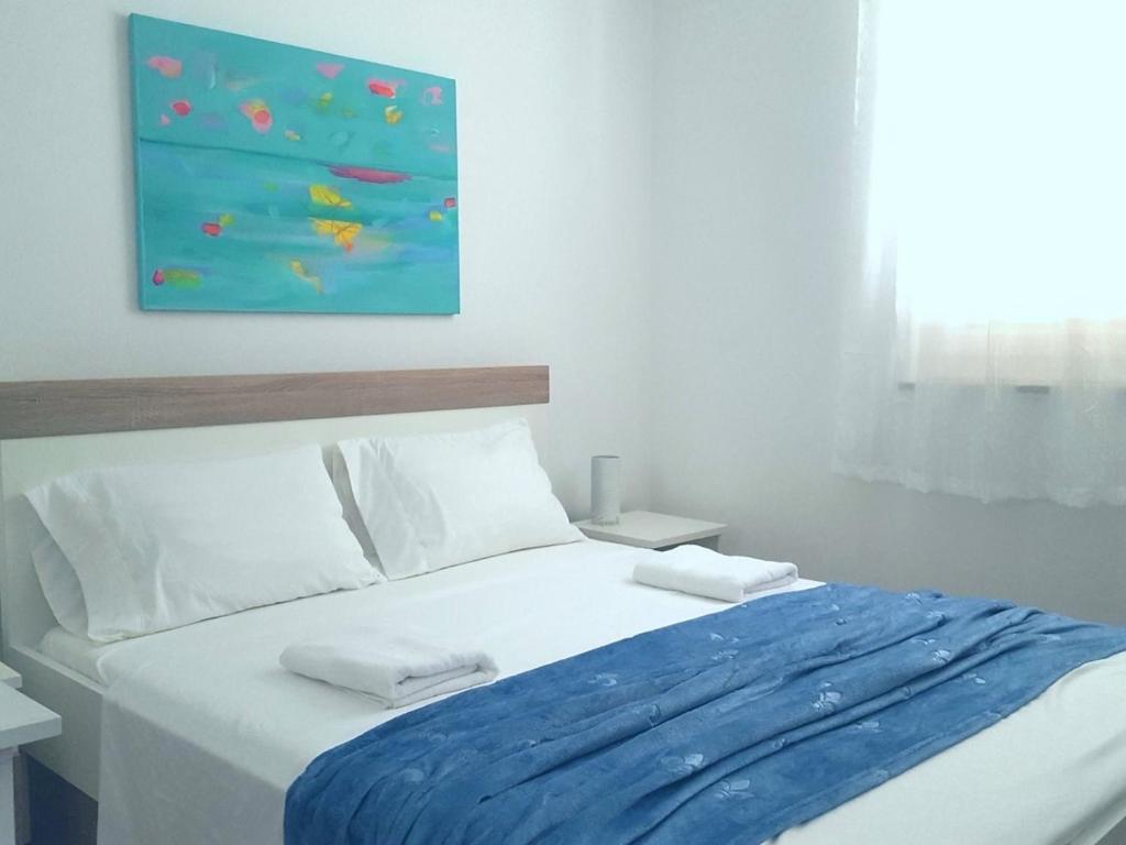 a bed with two pillows and a painting on the wall at Apartments Magdalena AS1 in Rovinj