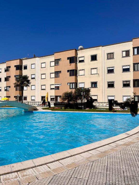een groot zwembad voor een gebouw bij Condomínio Del Rey in Charneca