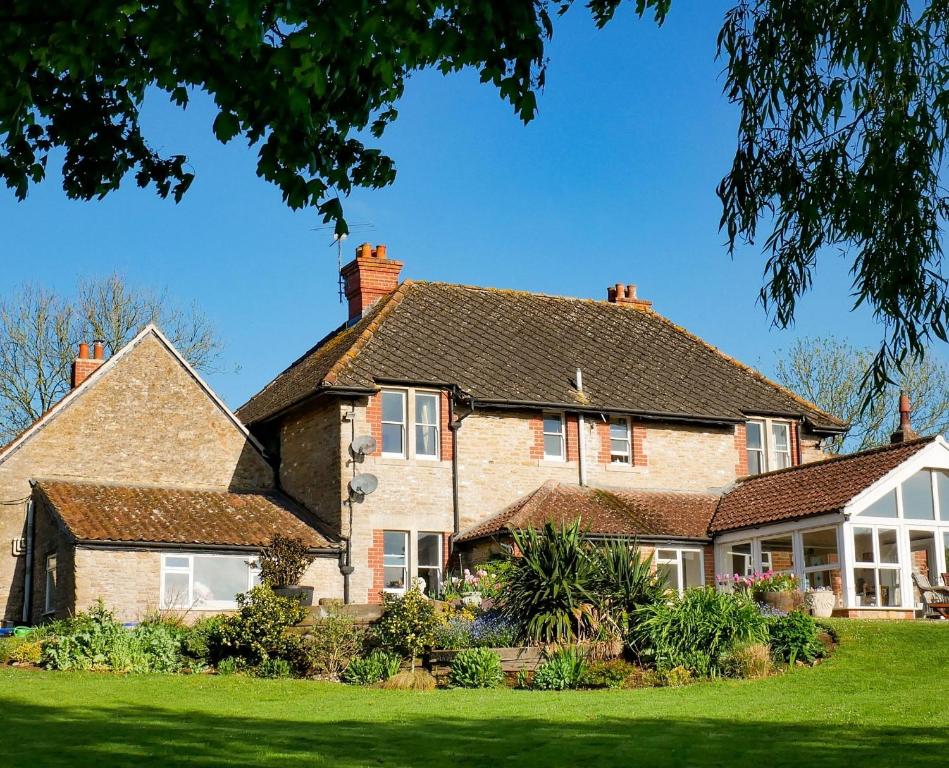 una gran casa de ladrillo con césped verde en Knoll Hill Farm, The Place To Stay, en Frome