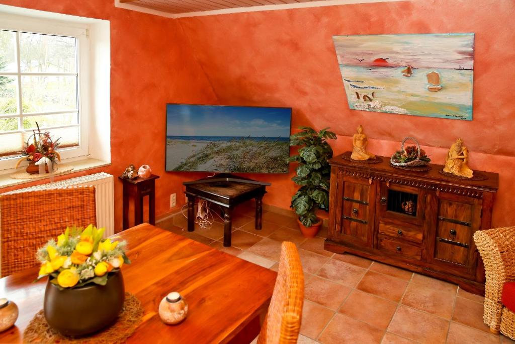 een woonkamer met een tafel en een televisie bij Ferienwohnung SONNENINSEL in Kühlungsborn