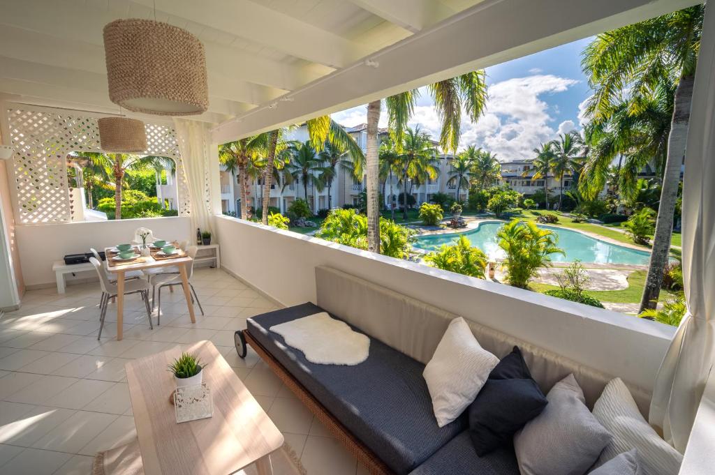 バヤイベにあるFamily Dominicus Apartment - Bayahibeのリビングルーム(ソファ付)が備わり、プールの景色を望めます。