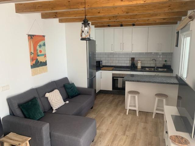 a living room with a couch and a kitchen at Casa El Rinconcito in Mijas