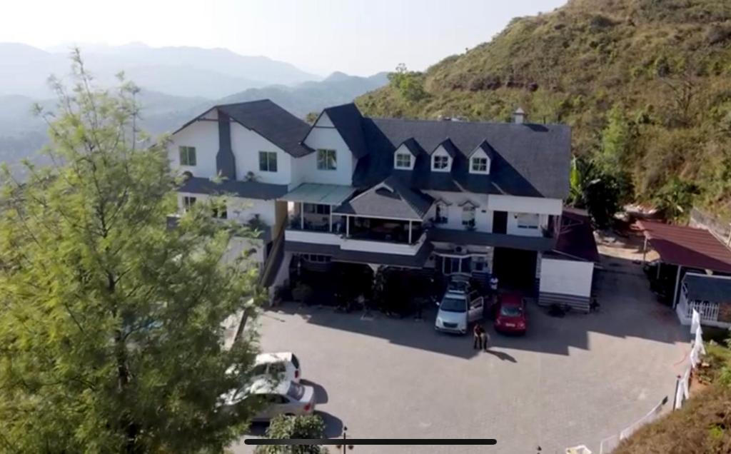 an aerial view of a house with a parking lot at kollanoor guest house in Madikeri