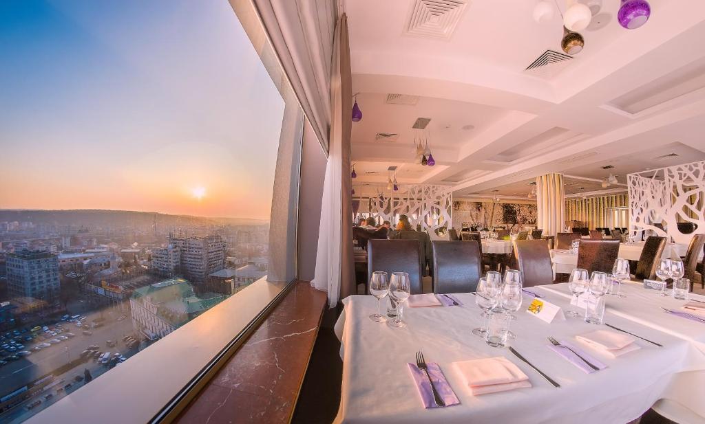 a restaurant with a long table with wine glasses at Unirea Hotel & Spa in Iaşi