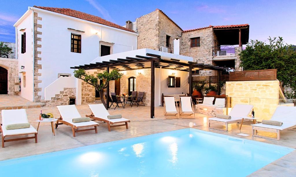 a villa with a swimming pool in front of a house at Villa Barozziana Private Heated Pool & Jacuzzi in Rethymno