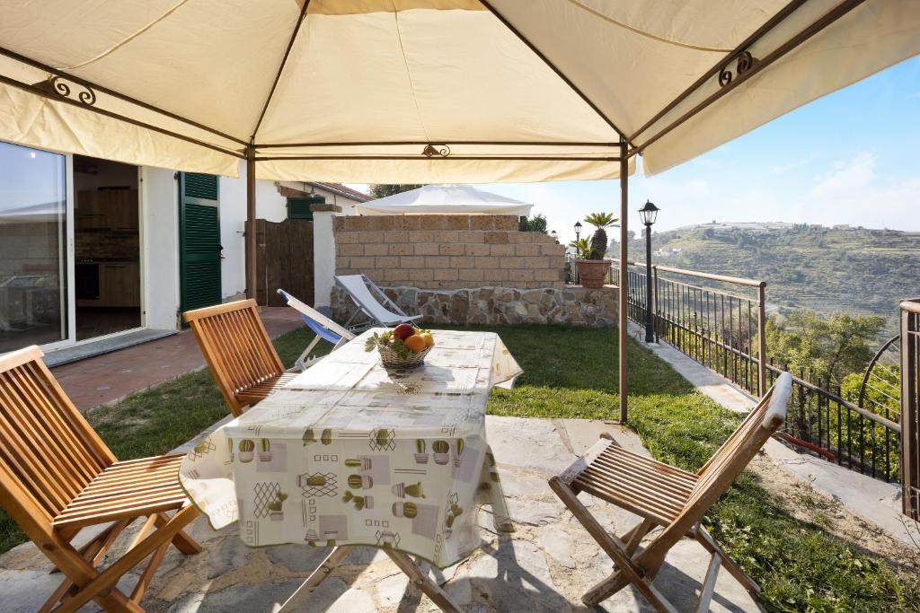 - une table et des chaises sous un parasol sur la terrasse dans l'établissement Timo, à Pompeiana