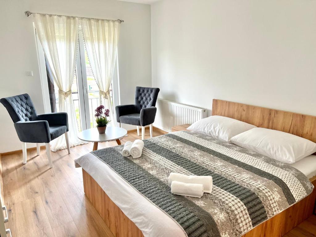a bedroom with a large bed and two chairs at Daman Villa in Bihać