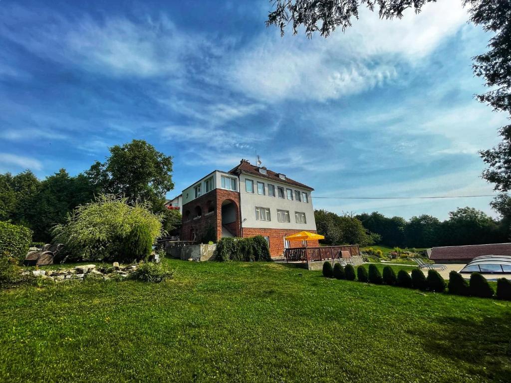 una casa grande en un campo de hierba con un edificio en Vila Hořičky en Hořičky