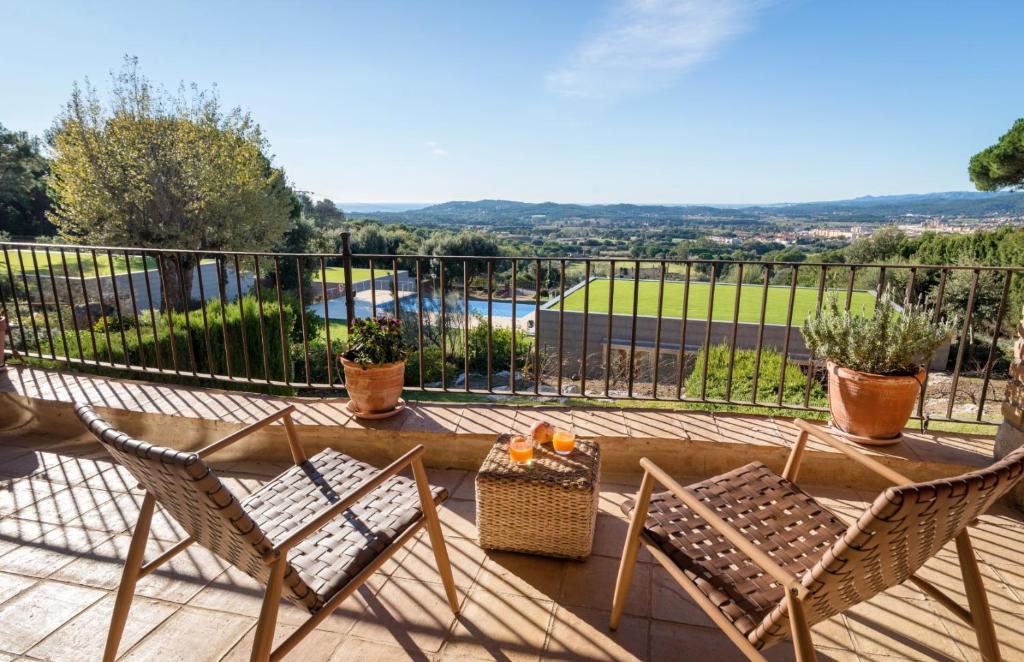a balcony with two chairs and a table with a view at Mas Ses Vinyes - Adults Only in Begur